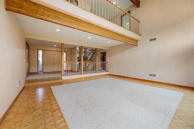 5 Byron Ln, Kirkland, NY 13323 - unfurnished living room with baseboards, beamed ceiling, recessed lighting, stairway, and a towering ceiling
