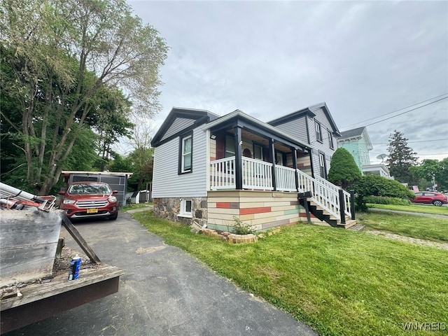 7 High St, Lyons, NY 14489 - view of front of home featuring covered porch, a front yard, stairway, and driveway