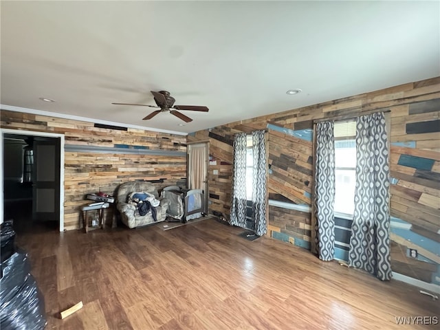 7 High St, Lyons, NY 14489 - unfurnished living room with wood walls, ceiling fan, and wood finished floors