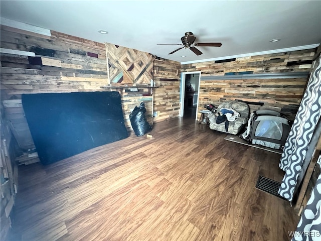 7 High St, Lyons, NY 14489 - unfurnished living room with wood walls, wood finished floors, a fireplace, and ceiling fan