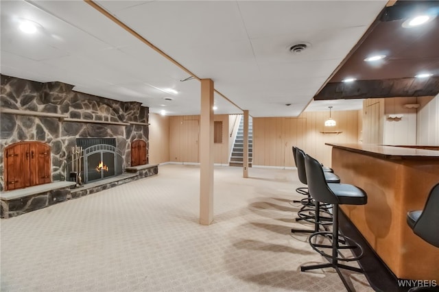 69 Coolidge Ave, Lockport-City, NY 14094 - finished basement with a bar, stairway, carpet, wood walls, and a stone fireplace