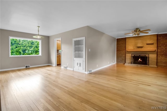 69 Coolidge Ave, Lockport-City, NY 14094 - unfurnished living room featuring ceiling fan, light wood-style flooring, a lit fireplace, and baseboards