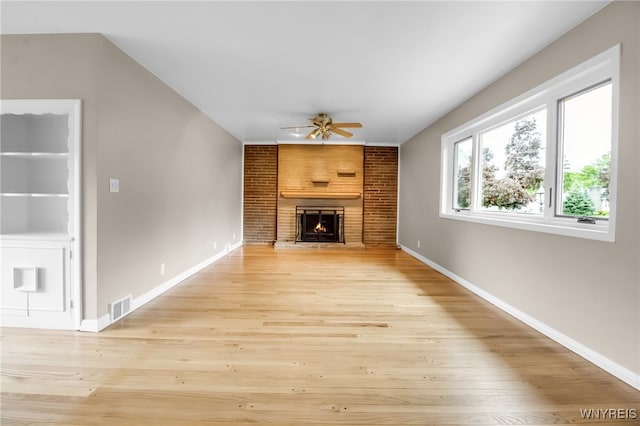 69 Coolidge Ave, Lockport-City, NY 14094 - unfurnished living room with ceiling fan, a large fireplace, light wood-type flooring, and baseboards