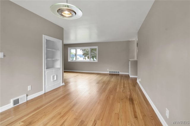 69 Coolidge Ave, Lockport-City, NY 14094 - unfurnished living room with light wood finished floors and baseboards