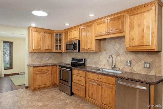 23 Bittersweet Ln, Orchard Park, NY 14127 - kitchen featuring stainless steel appliances, a sink, glass insert cabinets, decorative backsplash, and recessed lighting