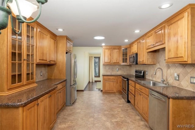 23 Bittersweet Ln, Orchard Park, NY 14127 - kitchen featuring stainless steel appliances, a sink, tasteful backsplash, recessed lighting, and glass insert cabinets