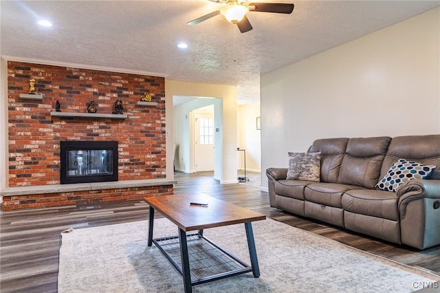 4335 US Route 11, Richland, NY 13142 - living room featuring wood finished floors, a textured ceiling, ceiling fan, baseboards, and a fireplace