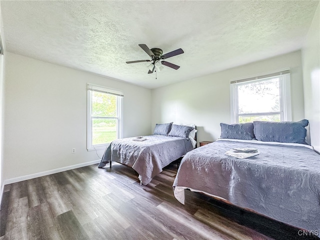 4335 US Route 11, Richland, NY 13142 - bedroom featuring wood finished floors, multiple windows, a textured ceiling, baseboards, and a ceiling fan