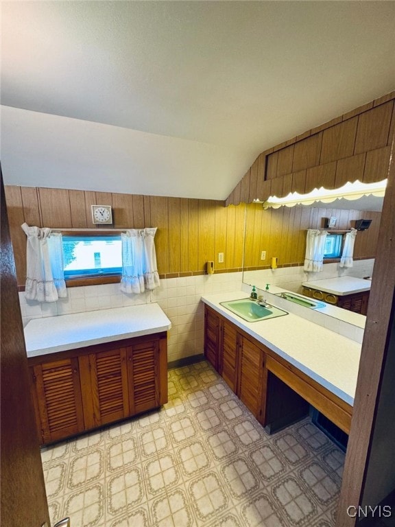 109 Clinton Ave, Cortland, NY 13045 - kitchen with brown cabinets, light countertops, light floors, wooden walls, and lofted ceiling