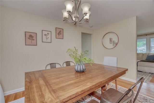 1 Ashton Dr, Gates, NY 14624 - dining space featuring a chandelier, baseboards, and light wood-style floors
