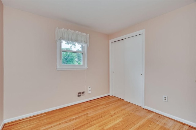 1 Ashton Dr, Gates, NY 14624 - unfurnished bedroom with wood finished floors, baseboards, and a closet