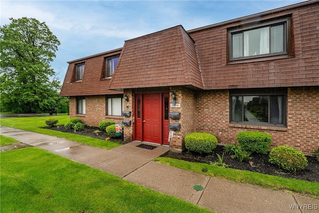 3898 Ridge Lea Rd Unit B, Amherst, NY 14228 - view of front of property featuring roof with shingles, mansard roof, brick siding, and a front lawn