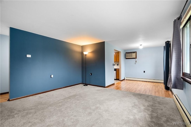 3898 Ridge Lea Rd Unit B, Amherst, NY 14228 - unfurnished living room featuring a baseboard radiator, light carpet, an AC wall unit, and baseboards