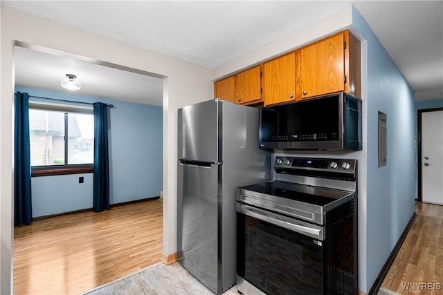 3898 Ridge Lea Rd Unit B, Amherst, NY 14228 - kitchen with appliances with stainless steel finishes, light wood-type flooring, brown cabinets, and baseboards