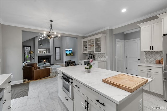 110 Hunt Club Cir, Amherst, NY 14051 - kitchen featuring a center island, white cabinets, glass insert cabinets, light stone countertops, and light marble finish flooring