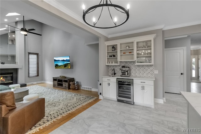 110 Hunt Club Cir, Amherst, NY 14051 - indoor bar with wine cooler, crown molding, a chandelier, tasteful backsplash, and light marble finish flooring