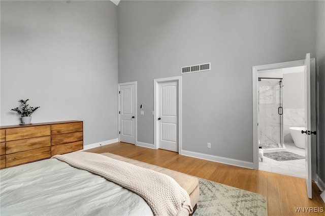 110 Hunt Club Cir, Amherst, NY 14051 - bedroom featuring a high ceiling, baseboards, wood finished floors, and ensuite bath
