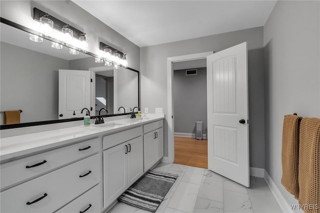 110 Hunt Club Cir, Amherst, NY 14051 - bathroom featuring double vanity, marble look tiles, and baseboards