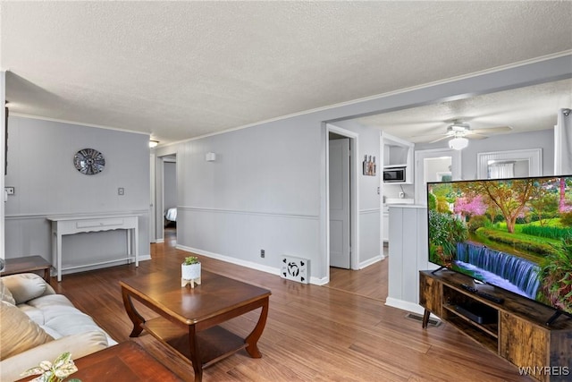 234 Clark St, Tonawanda-Town, NY 14223 - living room featuring a textured ceiling, ornamental molding, wood finished floors, a ceiling fan, and baseboards