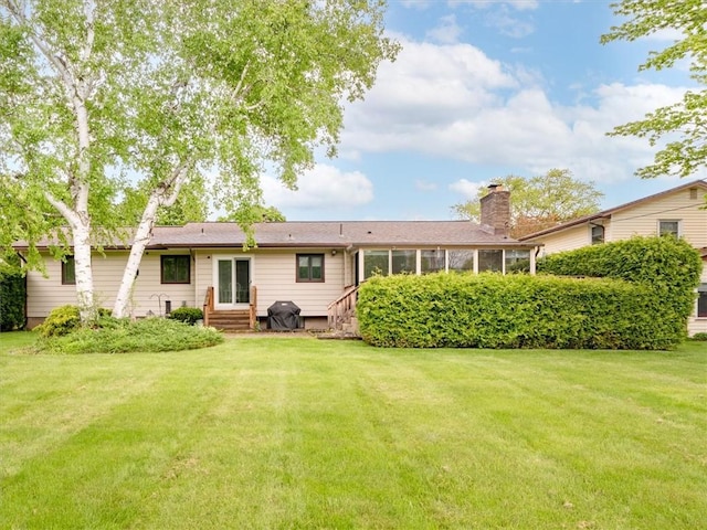 39 Sahara Dr, Gates, NY 14624 - rear view of property with entry steps, a lawn, a sunroom, and a chimney