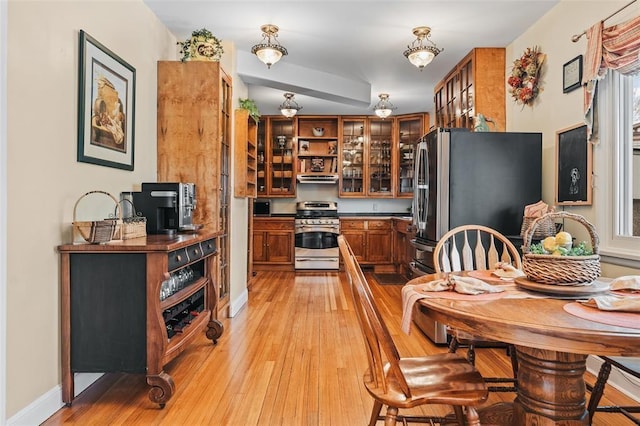 44 Riverside Dr, Binghamton-City, NY 13905 - kitchen featuring appliances with stainless steel finishes, brown cabinetry, light wood-style floors, and range hood