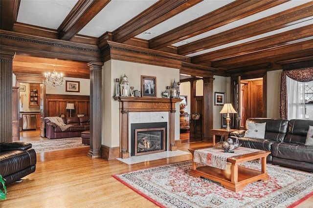 44 Riverside Dr, Binghamton-City, NY 13905 - living room with a chandelier, wood finished floors, beamed ceiling, a high end fireplace, and ornate columns