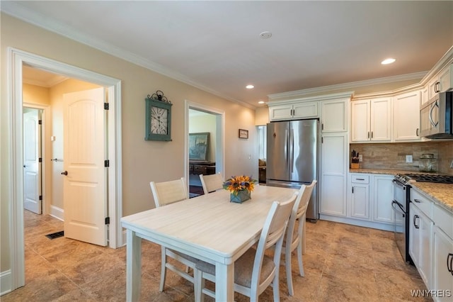 8785 Main St, Clarence, NY 14221 - kitchen featuring stainless steel appliances, crown molding, recessed lighting, tasteful backsplash, and light stone counters