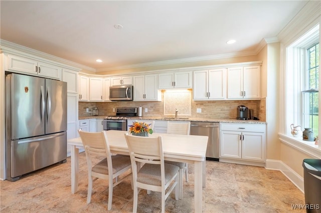 8785 Main St, Clarence, NY 14221 - kitchen with appliances with stainless steel finishes, a sink, white cabinetry, crown molding, and decorative backsplash