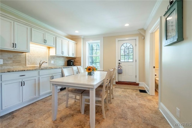 8785 Main St, Clarence, NY 14221 - kitchen featuring crown molding, a sink, tasteful backsplash, baseboards, and light stone countertops