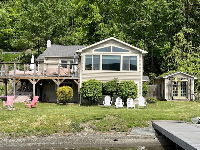 8976 Trio Dr, Urbana, NY 14840 - rear view of house featuring a wooden deck, a yard, an outbuilding, and a chimney