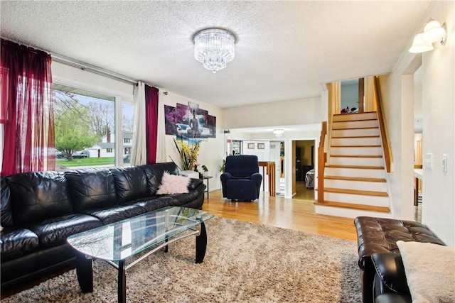 489 Bridgewood Dr, Greece, NY 14612 - living area featuring stairs, wood finished floors, a chandelier, and a textured ceiling
