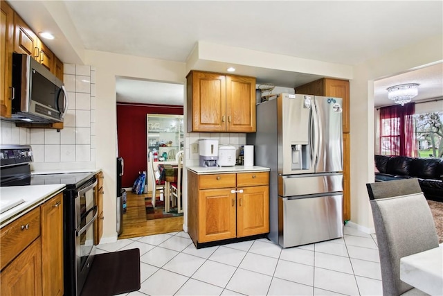 489 Bridgewood Dr, Greece, NY 14612 - kitchen featuring stainless steel appliances, light countertops, brown cabinetry, decorative backsplash, and recessed lighting