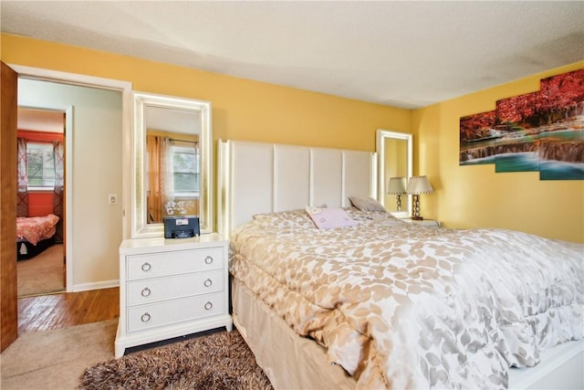489 Bridgewood Dr, Greece, NY 14612 - bedroom with multiple windows, wood finished floors, baseboards, and carpet floors