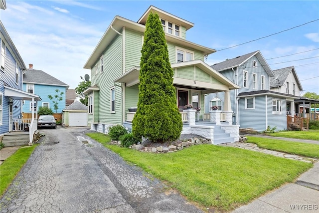 70 Seymour St, Tonawanda-City, NY 14150 - american foursquare style home featuring covered porch, a garage, a front lawn, asphalt driveway, and an outdoor structure