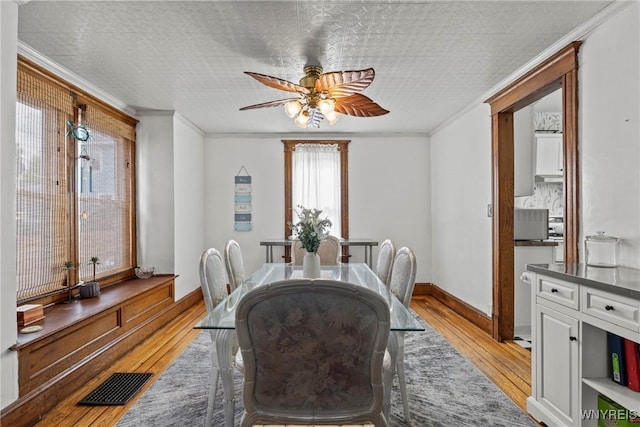 70 Seymour St, Tonawanda-City, NY 14150 - dining space with light wood-style flooring, a ceiling fan, crown molding, and baseboards
