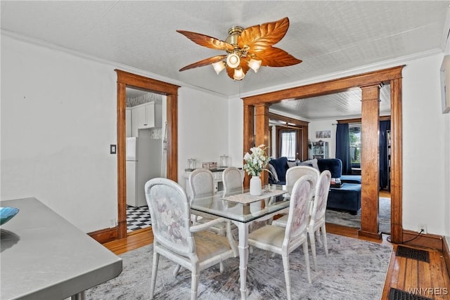 70 Seymour St, Tonawanda-City, NY 14150 - dining area featuring wood finished floors, ornamental molding, ceiling fan, and decorative columns