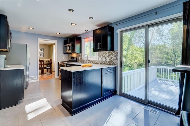 272 Shaftsbury Rd, Brighton, NY 14610 - kitchen featuring appliances with stainless steel finishes, decorative backsplash, a sink, a peninsula, and hanging light fixtures