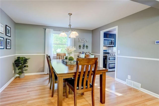 272 Shaftsbury Rd, Brighton, NY 14610 - dining area with light wood finished floors, baseboards, and a chandelier