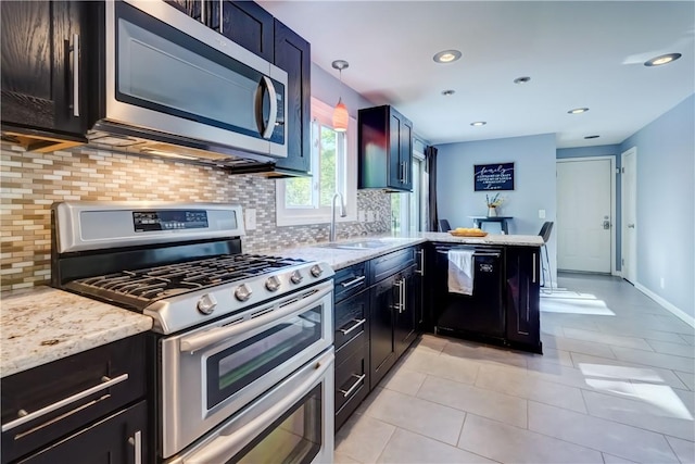 272 Shaftsbury Rd, Brighton, NY 14610 - kitchen with stainless steel appliances, a sink, decorative backsplash, a peninsula, and light stone counters