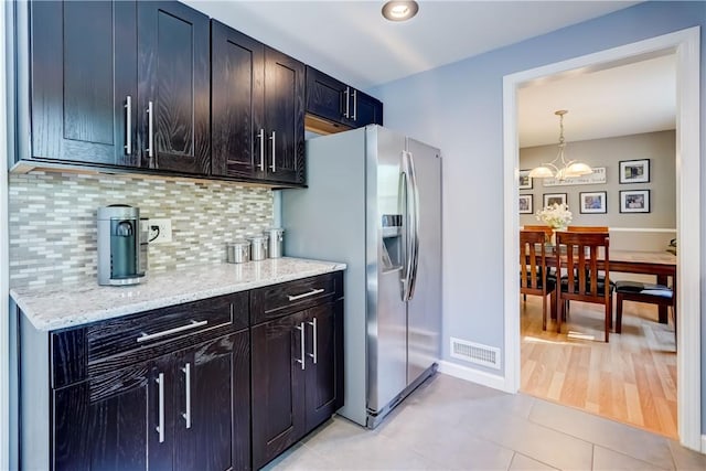 272 Shaftsbury Rd, Brighton, NY 14610 - kitchen featuring stainless steel fridge with ice dispenser, tasteful backsplash, light stone countertops, a chandelier, and light tile patterned floors