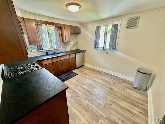 131 Hazelhurst Ave, Syracuse, NY 13206 - kitchen with a sink, stainless steel appliances, dark countertops, baseboards, and healthy amount of natural light
