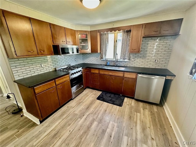 131 Hazelhurst Ave, Syracuse, NY 13206 - kitchen with appliances with stainless steel finishes, dark countertops, a sink, and backsplash