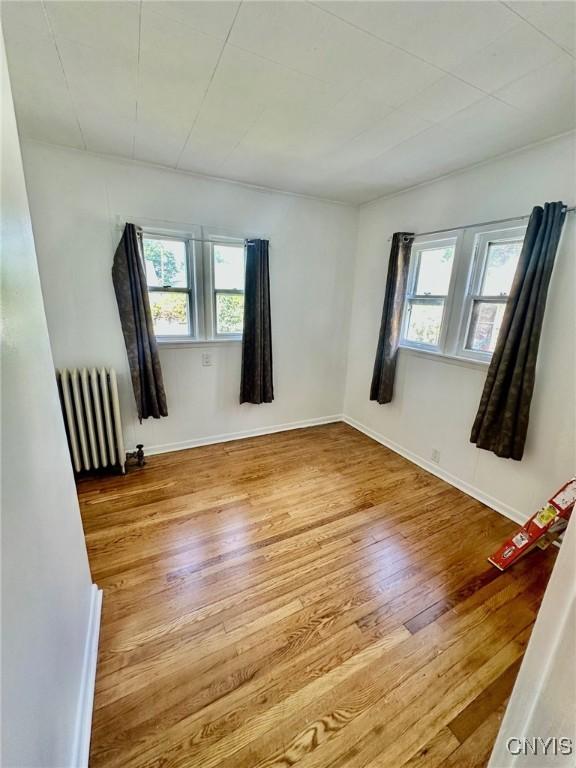 131 Hazelhurst Ave, Syracuse, NY 13206 - empty room featuring radiator heating unit, hardwood / wood-style flooring, and baseboards