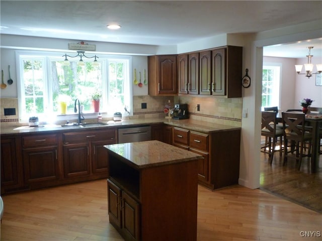 3899 Sweet Rd, Pompey, NY 13078 - kitchen with stainless steel dishwasher, a sink, decorative backsplash, light wood-style flooring, and light stone counters