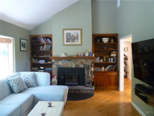 3899 Sweet Rd, Pompey, NY 13078 - living area featuring wood finished floors, lofted ceiling, and a stone fireplace