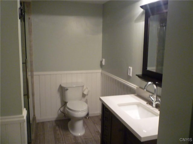 3899 Sweet Rd, Pompey, NY 13078 - full bathroom featuring a wainscoted wall, vanity, toilet, and wood finished floors