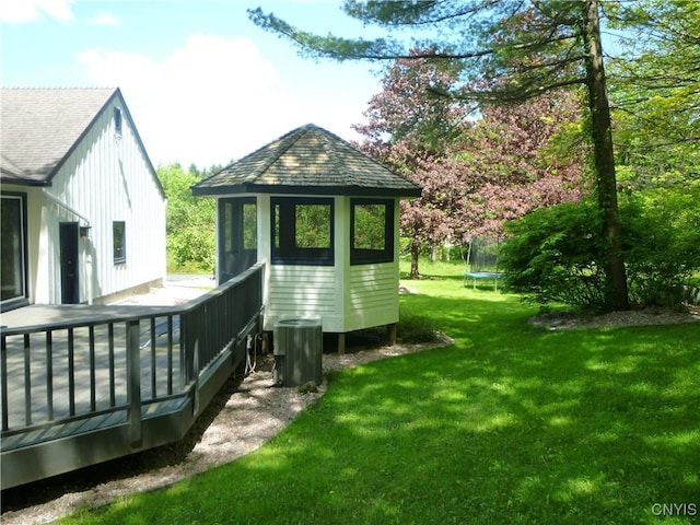 3899 Sweet Rd, Pompey, NY 13078 - back of property with a trampoline, a lawn, a deck, and board and batten siding