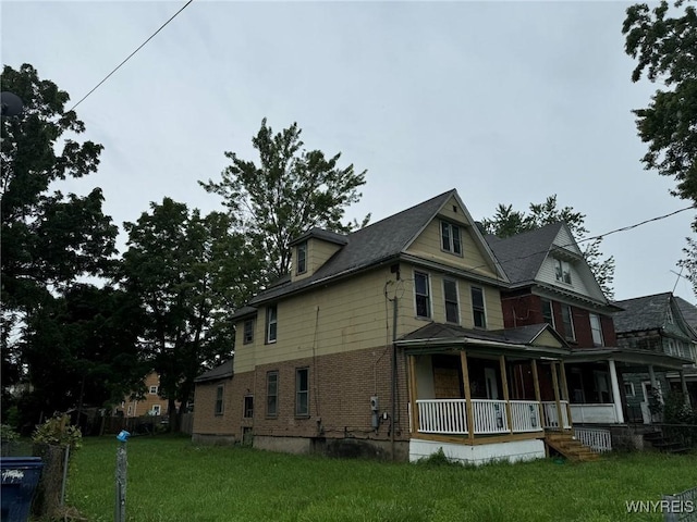 1867 Pierce Ave, Niagara Falls, NY 14301 - view of side of home with covered porch, a lawn, and brick siding