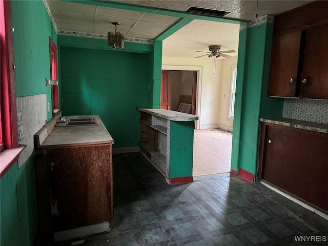 1867 Pierce Ave, Niagara Falls, NY 14301 - kitchen with dark flooring, a drop ceiling, a ceiling fan, a sink, and dark brown cabinetry