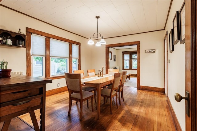 110 Lansdale St, Rochester, NY 14620 - dining room featuring baseboards, crown molding, hardwood / wood-style floors, and a chandelier